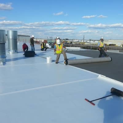 Workers replacing a commercial roof using commercial grade materials. We help the Denton Texas area.